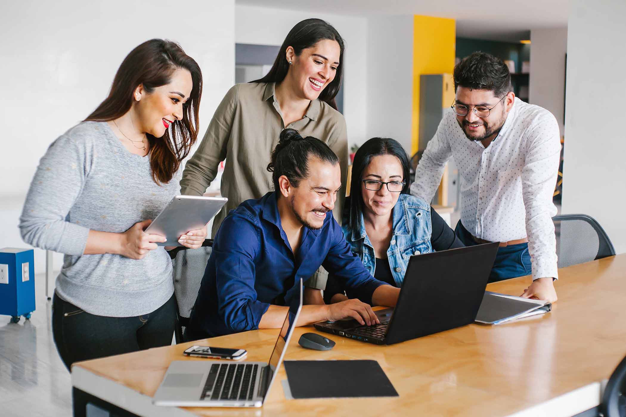 5 People Standing around Laptop